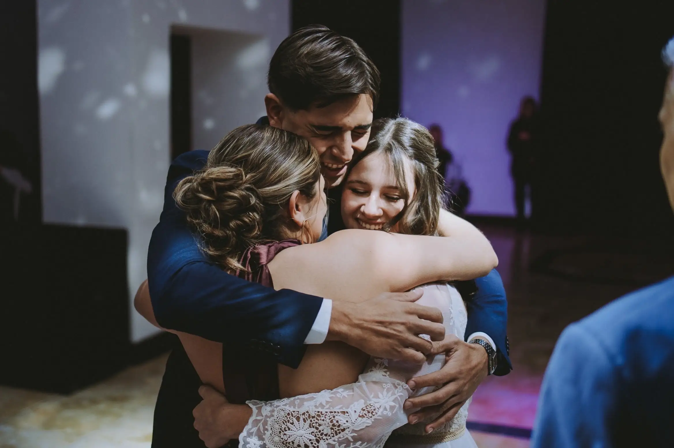 Un abrazo familiar a la quinceañera en medio de la fiesta.